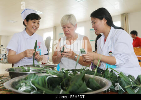 Lianyungan Lianyungan, Chine. 18 Juin, 2018. Lianyungang, Chine du 18e Juin 2018 : expert médical allemand M.S Edith Zeisig apprend à faire des boulettes de riz sur Dragon Boat Festival à Lianyungang, Chine de l'est la province de Jiangsu. Crédit : SIPA Asie/ZUMA/Alamy Fil Live News Banque D'Images