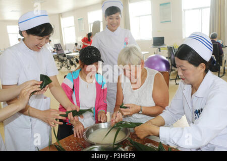 Lianyungan Lianyungan, Chine. 18 Juin, 2018. Lianyungang, Chine du 18e Juin 2018 : expert médical allemand M.S Edith Zeisig apprend à faire des boulettes de riz sur Dragon Boat Festival à Lianyungang, Chine de l'est la province de Jiangsu. Crédit : SIPA Asie/ZUMA/Alamy Fil Live News Banque D'Images