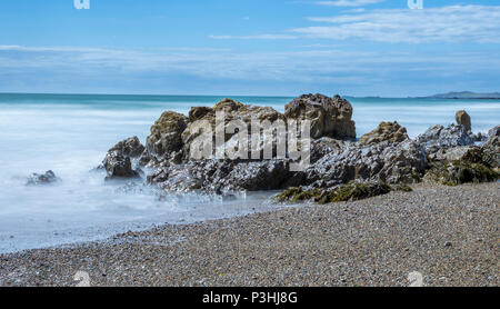 Une longue exposition de droit de la mer de lave autour des roches à Nobla Porth, conseil informatique sur l'île d'Anglesey. Banque D'Images