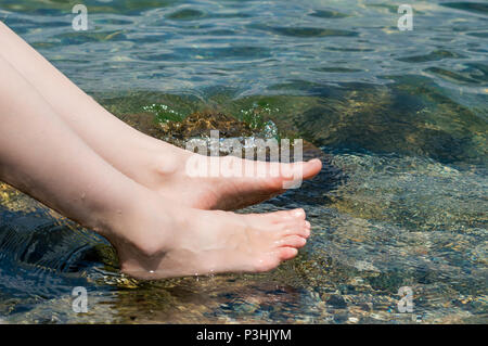 Young Caucasian woman's feet vous rafraîchir dans le lac sur une chaude journée d'été à Sapanca, Turquie Banque D'Images