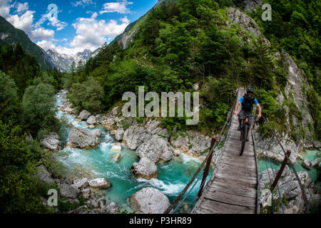 Une des promenades en vélo de montagne à travers un pont de bois sur la rivière Soca en Slovénie, l'Europe. Banque D'Images