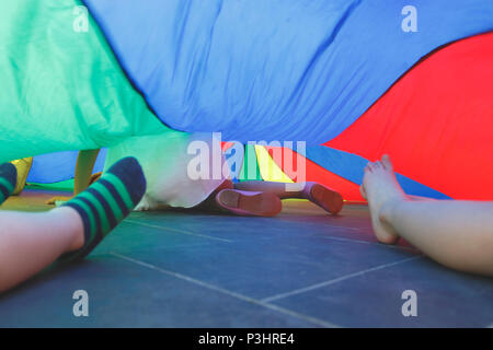 Enfants jouant sous un parachute Banque D'Images