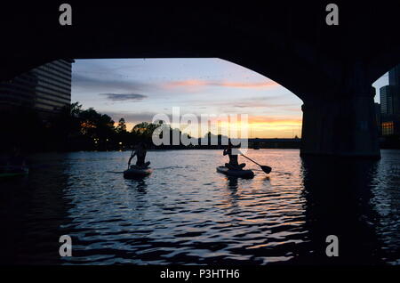 Deux filles paddle dans la soirée pour regarder la le Congrès ave les chauves-souris sortent sur le lac Coccinelle à Austin, Texas. Banque D'Images