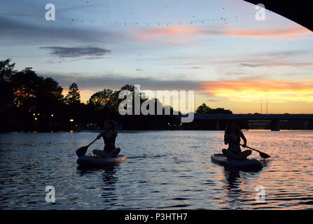 Deux filles paddle dans la soirée pour regarder la le Congrès ave les chauves-souris sortent sur le lac Coccinelle à Austin, Texas. Banque D'Images