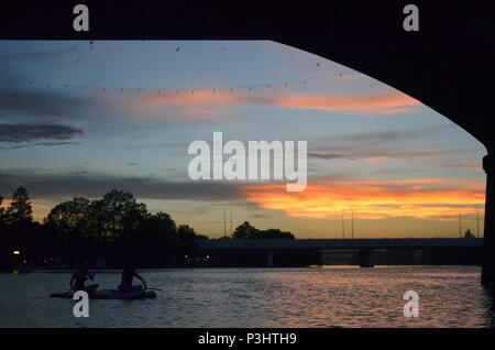 Deux filles paddle dans la soirée pour regarder la le Congrès ave les chauves-souris sortent sur le lac Coccinelle à Austin, Texas. Banque D'Images