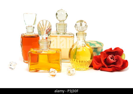 Flacons de parfum vintage avec les bouchons en verre, vieille poudre cosmétique et peluche rose rouge artificiel isolated on white Banque D'Images