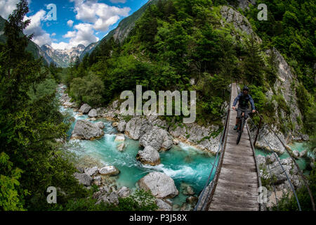 Une des promenades en vélo de montagne à travers un pont de bois sur la rivière Soca en Slovénie, l'Europe. Banque D'Images