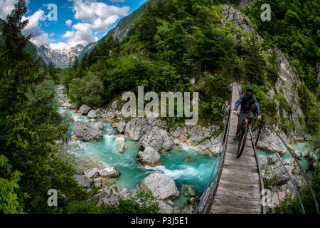 Une des promenades en vélo de montagne à travers un pont de bois sur la rivière Soca en Slovénie, l'Europe. Banque D'Images