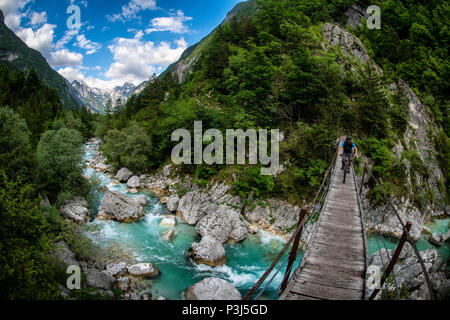 Une des promenades en vélo de montagne à travers un pont de bois sur la rivière Soca en Slovénie, l'Europe. Banque D'Images