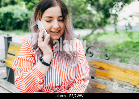 Belle Jeune femme admirant journée ensoleillée dans le parc pendant la saison des cerisiers en fleur Banque D'Images