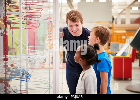 Les enfants et l'enseignant parle d'une exposition de la science Banque D'Images