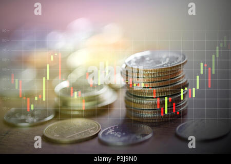 Pile de pièces en argent en faible profondeur de champ avec bougie bourse stick graphique. Banque D'Images