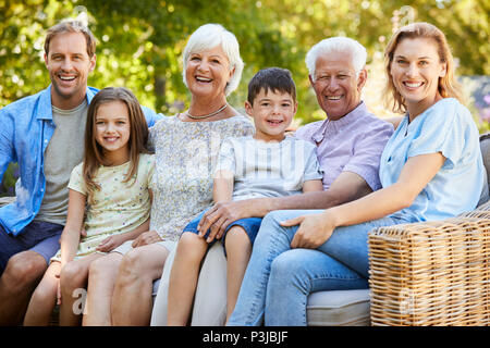 Family assis ensemble dans le jardin Banque D'Images