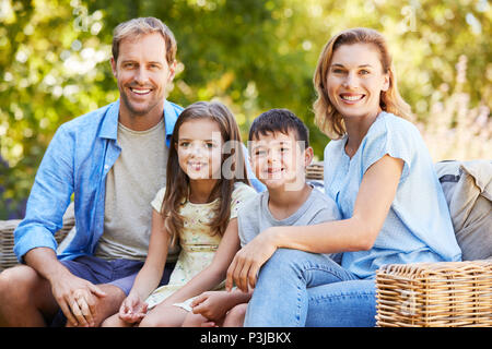 Jeune famille white assis ensemble dans le jardin Banque D'Images