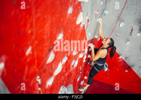 Portrait de femme pratiquant l'escalade sur un campus conseil. Woman climbing sur un campus conseil à un mur d'escalade. Banque D'Images