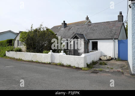 Un petit cottage modernisé avec un mur en pierre blanche et les piquets de clôture et porte dans le village de l'Ouest, WalesWales Pembrokeshire Marloes UK KATHY DEWITT Banque D'Images