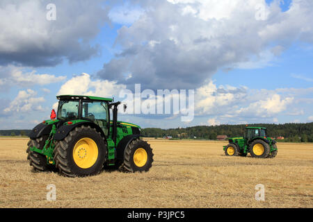 Deux modèles, les tracteurs John Deere 6210R et 6930 sur l'affichage sur des champs de Salo, Finlande, août 2012. Image éditoriale. Banque D'Images