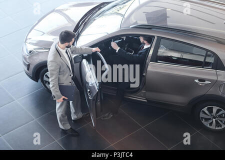 Vendeur de voiture de l'ouverture de la porte au Client Banque D'Images
