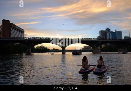 Deux filles paddle dans la soirée pour regarder la le Congrès ave les chauves-souris sortent sur le lac Coccinelle à Austin, Texas. Banque D'Images