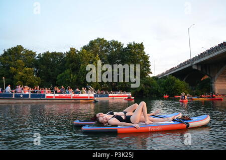 Deux filles paddle dans la soirée pour regarder la le Congrès ave les chauves-souris sortent sur le lac Coccinelle à Austin, Texas. Banque D'Images