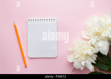 Le bloc-notes pour le texte des fleurs blanches sur fond rose pastel pivoine Banque D'Images