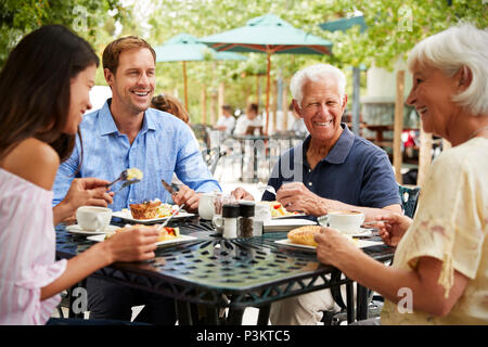 Les parents ayant des enfants adultes Enjoying Meal At Outdoor Cafe Banque D'Images