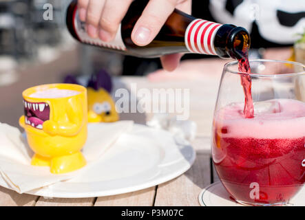 Café et du soleil. Un verre de bière de fruits belge. L'alcool sur la table. La bière coule à partir d'une bouteille. copy space Banque D'Images