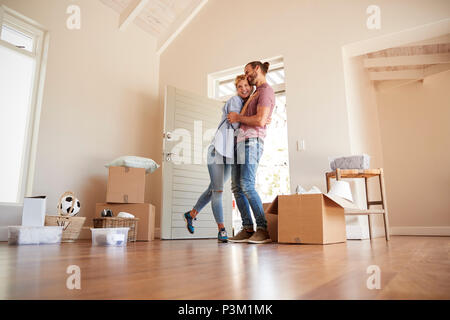 Heureux Couple entouré par des boîtes à New Home le jour du déménagement Banque D'Images