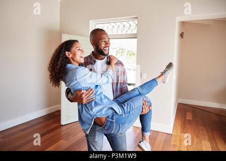 Man Carrying Woman au dessus du seuil de porte in New Home Banque D'Images