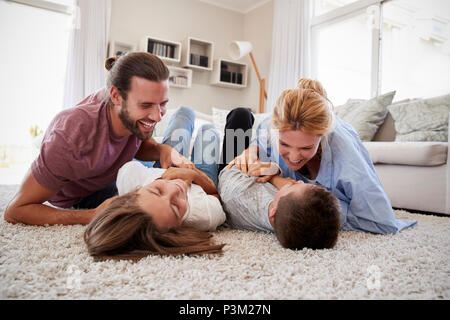 Les parents de chatouiller les enfants lorsqu'ils jouent ensemble dans le salon de jeu Banque D'Images