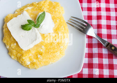 La polenta avec du fromage et de la crème dans une assiette. Banque D'Images