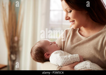 Mère de câliner bébé nouveau-né à la maison Banque D'Images