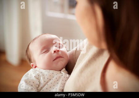 Close Up of Sleeping Newborn Baby étant détenu par Mère Banque D'Images