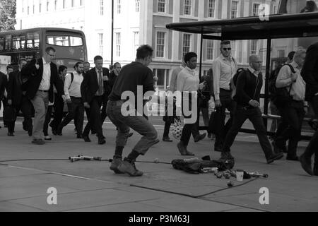 Jongleur de tenter de divertir les navetteurs et les employés de bureau sur le pont de Londres, Londres, Angleterre, Royaume-Uni, PETER GRANT Banque D'Images