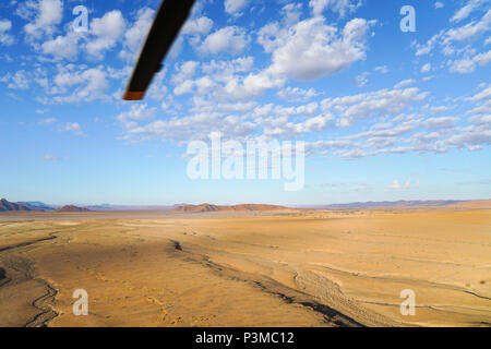 Paysage aérien, vaste zone plate qui s'étend à l'horizon avec un rotor d'Hélicoptère Vol en hélicoptère au-dessus de l'Namibie Sossusvlei. Banque D'Images