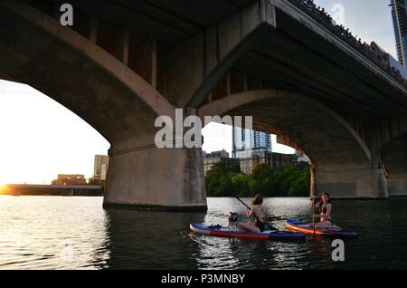Deux filles paddle dans la soirée pour regarder la le Congrès ave les chauves-souris sortent sur le lac Coccinelle à Austin, Texas. Banque D'Images
