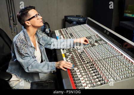 Femme à la mode le travail avec la console de musique Banque D'Images