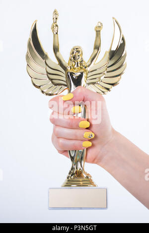 Statue Ange doré avec une torche et une main de femme à ailes ouvertes avec des ongles manucure jaune isolé sur fond blanc. Petite figure avec un socle de marbre Banque D'Images