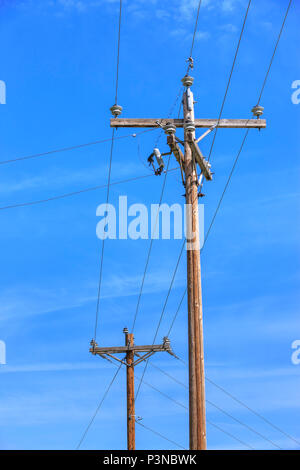 Image conceptuelle de poteau de téléphone et les fils contre un ciel bleu. Banque D'Images