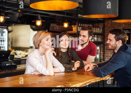 Réunion d'amis au bar avec intérieur loft Banque D'Images