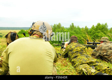 L'viv, Ukraine--A LES FORCES SPÉCIALES L'opérateur observe coups de feu tiré par un soldat Canadien de calibre .308 un fusil de sniper et un soldat polonais de fusil sniper calibre .50 ici le 18 juillet. La gamme a donné les partenaires multinationaux multinational interarmées à Group-Ukraine l'occasion de découvrir divers fusils de précision à partir des États-Unis, le Canada et l'Ukraine. JMTG-U est un effort multinational pour former des unités de combat défensif ukrainien sur les compétences nécessaires pour accroître la capacité de l'Ukraine pour l'auto-défense. (U.S. Photo de l'armée par le Capitaine Scott Kuhn) Banque D'Images