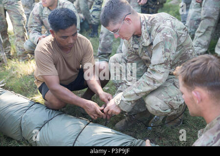 L'Armée Philippine Tech. Le Sgt. Romeo A. Soriano, à gauche, montre la façon d'obtenir des cordes pour un pis-flottaison pendant l'entraînement de survie à l'appui de Balikatan 2017 au Fort Ramon Magsaysay, Nueva Ecija, le 9 mai 2017. Cette formation aide les deux armées sont prêtes à aider les victimes de catastrophes naturelles et de crises dans les zones éloignées et austère des Philippines. Balikatan est un américain annuel-exercice militaire bilatérale des Philippines a porté sur une grande variété de missions, y compris l'aide humanitaire et des secours en cas de catastrophe, la lutte contre le terrorisme, et d'autres opérations militaires conjointes. Banque D'Images