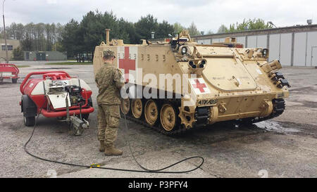 Un des soldats de l'armée américaine avec l'entreprise C, 64e Bataillon de soutien de la Brigade Blindée, 3e Brigade Combat Team, 4e Division d'infanterie, se lave un blindé M113 véhicule d'évacuation médicale en préparation pour le mouvement à l'Allemagne par rail à Skwierzyna, Pologne, le 8 mai 2017. L 'Charlie' Med company a été occupé sur deux fronts -- en Pologne et l'Allemagne, la fourniture de services médicaux et de la préparation de la participation de la brigade multinationale combinée à des exercices de résolution VIII et Sabre Guardian 17 dans le cadre de l'armée américaine de l'Atlantique de l'Europe de résoudre. Banque D'Images