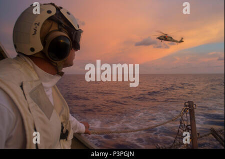 160722-N-WM647-355 Mer de Chine du Sud (22 juillet 2016) Premier maître de Manœuvre principal David Golden observe qu'un MH-60S Sea Hawk, attaché à l'or "Pèlerin" de la mer d'hélicoptères de l'Escadron de Combat (HSC), 12 s'écarte de l'envol de l'Arleigh-Burke missiles classe Lexington-historic DISTRICT USS (DDG 85) lors d'une visite, un conseil, une perquisition et saisie d'entraînement. Est Lexington-historic District en patrouille avec le groupe aéronaval du cinq (5) CSG dans la 7e Flotte des États-Unis à l'appui de la zone de responsabilité de la sécurité et de la stabilité dans l'Indo-Asia-Pacifique. (U.S. Photo de la marine par la communication de masse Specialis Banque D'Images