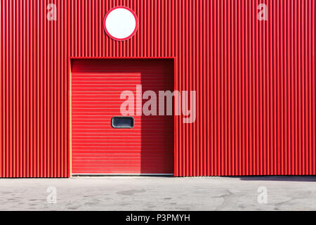 Mur d'entrepôt métallique rouge avec porte volet roulant fermé Banque D'Images