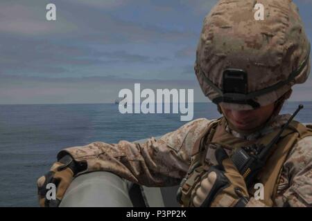 USS MAKIN ISLAND, en mer - Sgt. Jojadys Hernandez, un planificateur de carrière avec la 11e Marine Expeditionary Unit, répond à une mise à jour de la situation sur sa radio tout en dépôt de garantie au cours d'une défense de la force opérationnelle amphibie percer au cours d'un exercice en commun des détroits comme faisant partie de l'Escadron amphibie - MEU Intégration formation exercice 14 juillet 2016. Un navire va exécuter DATF et la posture des Marines et marins défensivement autour de leurs navires lors de la confirmation d'une menace possible près de l'ARG/MEU. (U.S. Marine Corps photo par le s.. Scott McAdam/libérés) Banque D'Images