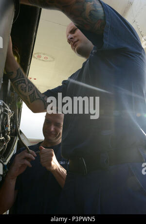 Maître de 2e classe Michael Harman et maître de 2e classe Mike Saylor, techniciens de maintenance de l'aviation de la Garde côtière à Air Station barbiers Point, Oahu, Hawaii, se préparer à le remplacer un brûleur bouchon sur un avion Hercules HC-130 à l'aéroport international de Pago Pago dans les Samoa américaines, le 26 juillet 2016. L'équipage de la Garde côtière canadienne a visité les Samoa américaines de mener des opérations de pêche dans le Pacifique, ainsi qu'offrir des possibilités de diffusion externe de recrutement de membres au sein de la communauté. (U.S. Photo de la Garde côtière du Maître de 2e classe Tara Molle/libérés) Banque D'Images