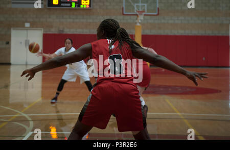 Pays membre de l'International du Sport Militaire (CISM) Conseil sont réunis pour participer à l'Organisation mondiale des femmes militaires, Tournoi de basket-ball, commençant à la page Field House à Camp Pendleton, Californie, 25 juillet 2016. Aux États-Unis et au Canada les équipes s'affrontent dans le dernier match de la première journée du tournoi, prévu d'aller jusqu'en juillet 29. Le capitaine Amsatou Diallo de l'équipe canadienne s'accroupit dans une position de blocage pour stopper une offensive en voiture par l'équipe des États-Unis. (U.S. Marine Corps photo par Lance Cpl. Micha R. Pierce/libérés) Banque D'Images