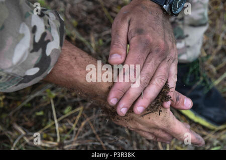 160718-F-DF491-0033 - Pohakuloa Zone de formation, New York - Un projet pilote avec le 353e Escadron de soutien des opérations spéciales, camoufle ses mains avec de la terre dans le cadre de la survie, évasion, résistance et échapper à une formation de recyclage au cours de l'EXERCICE RIMPAC au secteur d'entraînement de Pohakuloa, New York, le 18 juillet 2016. Vingt-six nations, 49 navires, 6 sous-marins, environ 200 avions et 25 000 personnes participent à l'EXERCICE RIMPAC 16 du 29 juin au 4 août dans et autour des îles Hawaï et la Californie du Sud. Le plus grand exercice maritime international RIMPAC, fournit une formation unique tandis que Foster Banque D'Images