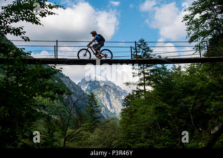 Une des promenades en vélo de montagne à travers un pont de bois sur la rivière Soca en Slovénie, l'Europe. Banque D'Images